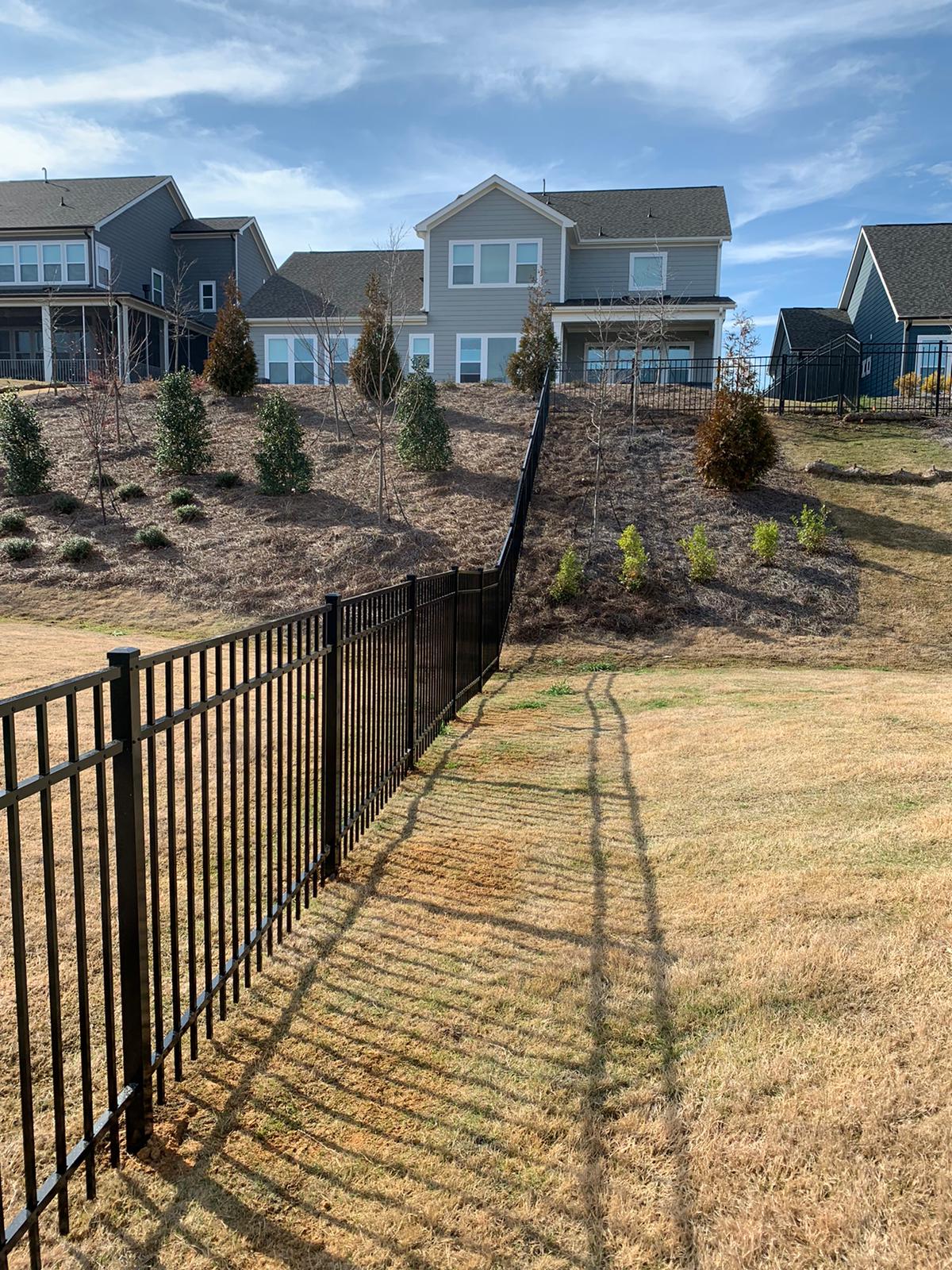 A black Aluminum fence on a hill backyard in Charlotte | Fence company Charlotte NC